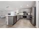 Modern kitchen boasting stainless steel appliances, gray cabinetry, and an open layout to the living room at 1719 Daystar Dr, Haines City, FL 33844