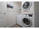 Convenient laundry room featuring a stacked washer and dryer, plus built-in shelving for storage at 1719 Daystar Dr, Haines City, FL 33844