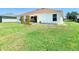 A spacious backyard featuring a patio area, green grass and a well maintained garden at 1912 Manatee Ln, Poinciana, FL 34759