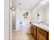 Bright bathroom featuring a soaking tub with tile surround, walk-in shower, and double sink vanity at 1912 Manatee Ln, Poinciana, FL 34759