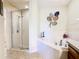 Bathroom featuring a soaking tub with tile surround, and walk-in shower with glass door at 1912 Manatee Ln, Poinciana, FL 34759
