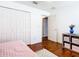 Bedroom with hardwood floors, a closet and a view of the door to the hallway at 1912 Manatee Ln, Poinciana, FL 34759