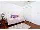 Bedroom with hardwood floors, closet, and a bedside table at 1912 Manatee Ln, Poinciana, FL 34759