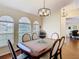 Elegant dining room featuring a classic wood table, decorative chandelier, and arched windows at 1912 Manatee Ln, Poinciana, FL 34759
