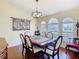 Elegant dining room featuring a classic wood table, decorative chandelier, and arched windows at 1912 Manatee Ln, Poinciana, FL 34759