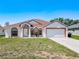 Charming single-story home featuring a symmetrical facade, arched windows, and a well-manicured lawn at 1912 Manatee Ln, Poinciana, FL 34759