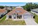 Charming single-story home featuring a symmetrical facade, arched windows, and a well-manicured lawn at 1912 Manatee Ln, Poinciana, FL 34759