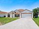 Charming single-story home featuring a symmetrical facade, arched windows, and a well-manicured lawn at 1912 Manatee Ln, Poinciana, FL 34759