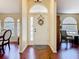 Inviting foyer with gleaming wood floors, a decorative front door with wreath, and arched windows at 1912 Manatee Ln, Poinciana, FL 34759