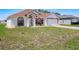 Charming single-story home featuring a symmetrical facade, arched windows, and a well-manicured lawn at 1912 Manatee Ln, Poinciana, FL 34759