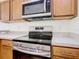 Close-up of the oven and stovetop with stainless steel appliances and light countertops at 1912 Manatee Ln, Poinciana, FL 34759