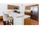 Kitchen with breakfast bar, stainless steel appliances, wood cabinets, and hardwood floors at 1912 Manatee Ln, Poinciana, FL 34759