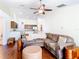 Spacious open-concept living room and kitchen with hardwood floors and a ceiling fan at 1912 Manatee Ln, Poinciana, FL 34759