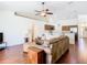 Open-concept living room and kitchen, complete with hardwood floors, a ceiling fan, and stainless steel appliances at 1912 Manatee Ln, Poinciana, FL 34759