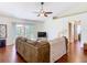 Bright living room featuring hardwood floors, a ceiling fan, and sliding glass doors leading to an outdoor patio at 1912 Manatee Ln, Poinciana, FL 34759