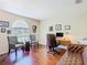 Bright office space featuring hardwood floors, a window with blinds, a desk, and stylish seating arrangements at 1912 Manatee Ln, Poinciana, FL 34759