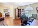 Office space with hardwood floors, a built-in bookcase, and a view into the dining area at 1912 Manatee Ln, Poinciana, FL 34759