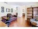 Open office area with hardwood floors and a comfortable leather couch leading to other rooms at 1912 Manatee Ln, Poinciana, FL 34759
