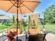 Outdoor patio with a stylish seating area featuring an umbrella and decorative plants at 1912 Manatee Ln, Poinciana, FL 34759