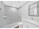 Modern bathroom features sleek white vanity, white shower tiles, and gray wood-look floors at 2 Dogwood Radl, Ocala, FL 34472