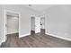 Bedroom featuring gray tone walls with a view to the bathroom and kitchen and gray wood-look floors at 2 Dogwood Radl, Ocala, FL 34472