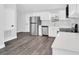 Bright kitchen featuring new stainless steel appliances, white cabinets, and durable gray wood-look flooring at 2 Dogwood Radl, Ocala, FL 34472