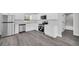 Modern kitchen featuring stainless steel appliances, white cabinets, and durable gray wood-look flooring at 2 Dogwood Radl, Ocala, FL 34472