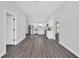 Bright open-concept kitchen with stainless steel appliances, white cabinets, and luxury vinyl plank flooring at 2 Dogwood Radl, Ocala, FL 34472