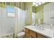 Bright bathroom features a vanity with framed mirror, tub with shower, and neutral decor at 201 Largo Dr, Kissimmee, FL 34759