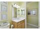 Well-lit bathroom with light green walls, vanity, toilet, and framed coastal artwork at 201 Largo Dr, Kissimmee, FL 34759