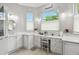 Bright bathroom featuring white cabinets, a vanity area with natural light, and neutral tile floors at 201 Largo Dr, Kissimmee, FL 34759