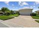 Charming home featuring a two-car garage, brick driveway, and well-manicured lawn at 201 Largo Dr, Kissimmee, FL 34759