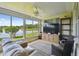 Relaxing sunroom with lake views, comfortable seating, and a large entertainment center at 201 Largo Dr, Kissimmee, FL 34759