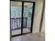View of the balcony with railing, trees, and a sliding door to the bedroom interior at 2031 Balboa Way, Kissimmee, FL 34741