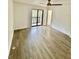 Spacious bedroom with light wood-look flooring, sliding glass doors to balcony, and ceiling fan at 2031 Balboa Way, Kissimmee, FL 34741