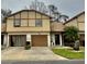 Two-story tan home with brown trim, attached garage, and well-manicured front lawn at 2031 Balboa Way, Kissimmee, FL 34741