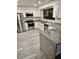 Bright kitchen features gray granite countertops, stainless steel appliances, and modern wood flooring at 2031 Balboa Way, Kissimmee, FL 34741