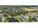 Expansive aerial view of a residential neighborhood with mature trees, a community pool, a pond, and a tennis court at 2146 Fish Eagle St, Clermont, FL 34714