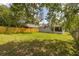 Well-maintained back yard features a wood fence, grassy area, and mature trees at 2146 Fish Eagle St, Clermont, FL 34714