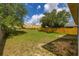 Large grassy backyard with a wooden fence and distant hills at 2146 Fish Eagle St, Clermont, FL 34714