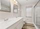 A clean bathroom with dual sinks, mirrors, a shower with a glass door, and a window at 2146 Fish Eagle St, Clermont, FL 34714