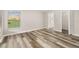 Bright bedroom with a window, wood flooring, walk-in closet, and neutral paint throughout the room at 2146 Fish Eagle St, Clermont, FL 34714