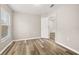 Neutral bedroom featuring wood-look floors, light gray walls, and a window with blinds at 2146 Fish Eagle St, Clermont, FL 34714