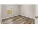 Bedroom features wood-look flooring, neutral walls, and a window with blinds at 2146 Fish Eagle St, Clermont, FL 34714
