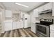 Well-lit kitchen boasts white cabinets, stainless steel appliances, and modern countertops at 2146 Fish Eagle St, Clermont, FL 34714