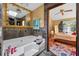 Bathroom featuring a tub, a large mirror with floral accents, and an open door to the main bedroom at 2225 Maryday Ct, Orlando, FL 32812