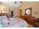 Bedroom featuring a floral bedspread, a ceiling fan, and a large mirror above the dresser at 2225 Maryday Ct, Orlando, FL 32812
