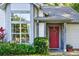 Close up of home's front door, with lush landscaping and large windows creating a welcoming curb appeal at 2225 Maryday Ct, Orlando, FL 32812