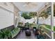 Cozy screened patio with wicker furniture, ceiling fan, and string lights overlooks the backyard at 2225 Maryday Ct, Orlando, FL 32812