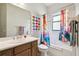 A primary bathroom featuring a colorful shower curtain, vanity, and towel rack at 271 Indian Wells Ave, Poinciana, FL 34759